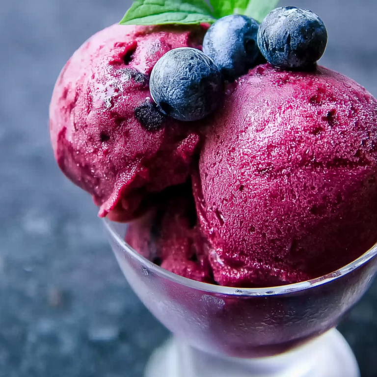 Three-Ingredient Blueberry Sorbet served in a bowl with fresh blueberries and mint garnish