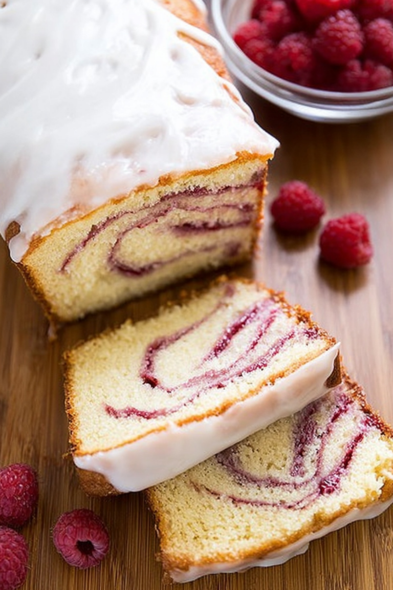 Yogurt Cake with Raspberry Swirl topped with creamy yogurt glaze and fresh raspberries