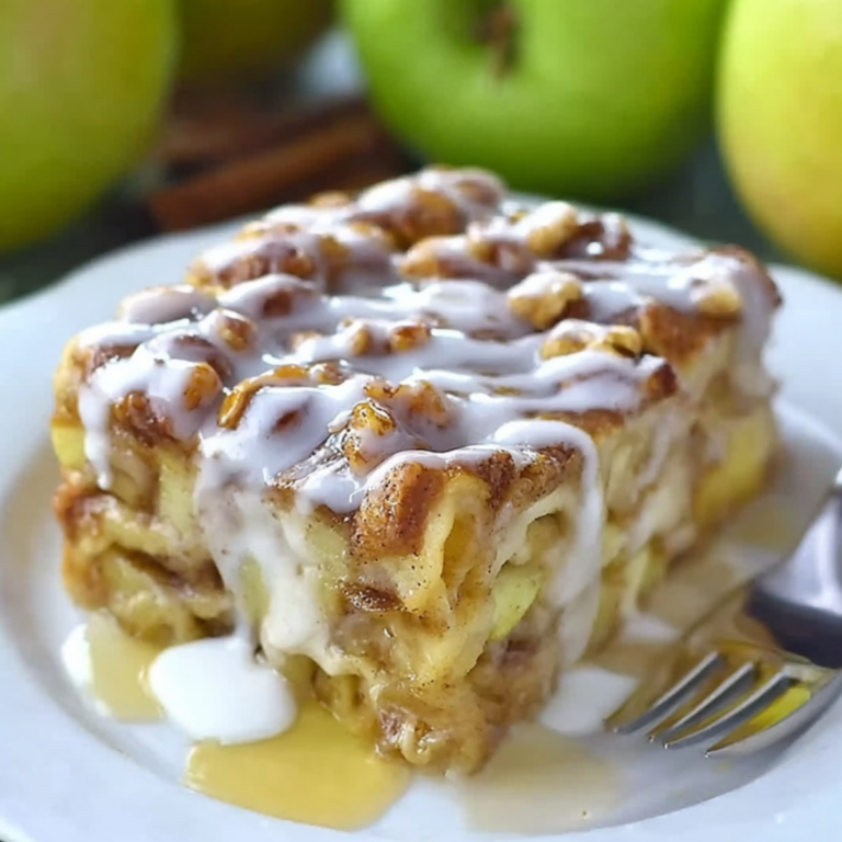 Caramel Apple Cinnamon Roll Lasagna layered with cinnamon rolls, apples, cream filling, and caramel sauce